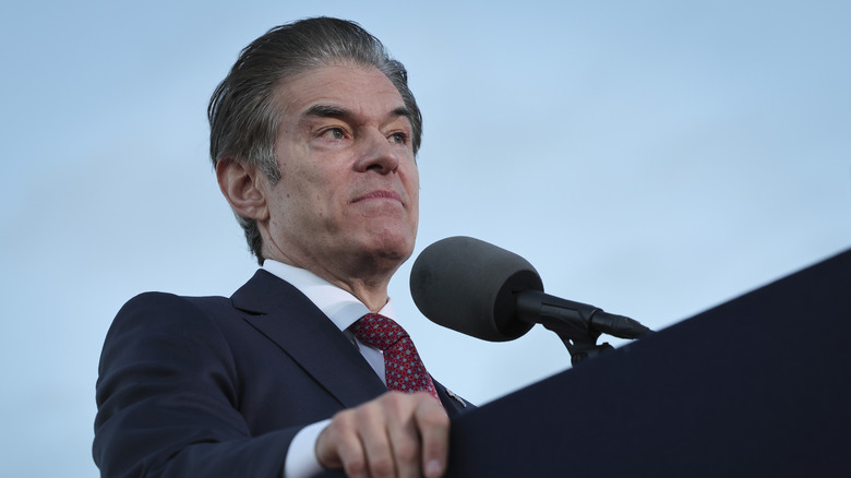 Dr. Oz giving a speech in a black suit while looking annoyed