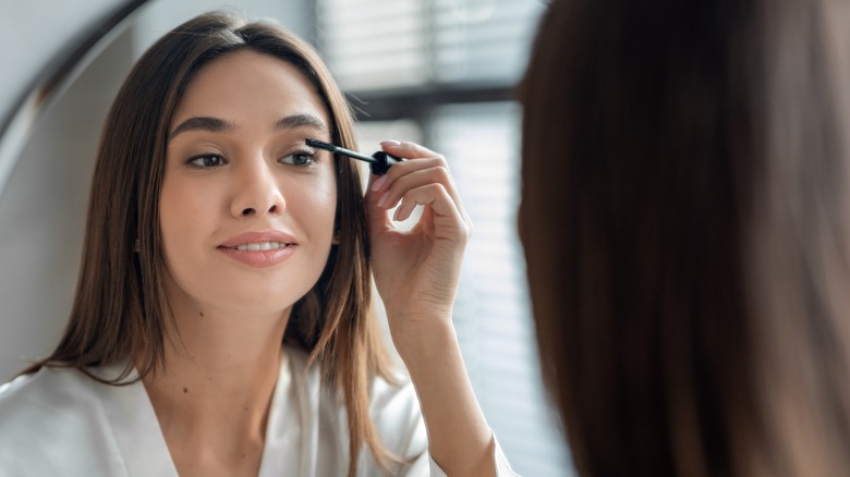 woman applying mascara 