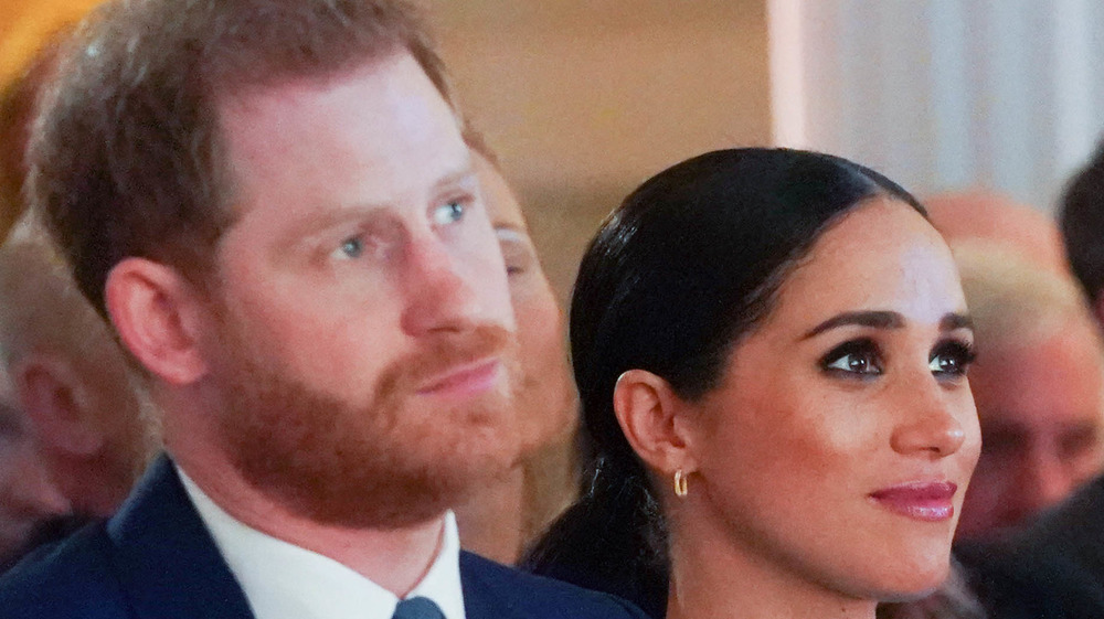 Prince Harry and Meghan Markle looking serious