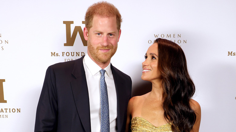 Prince Harry and Meghan Markle posing on the red carpet 