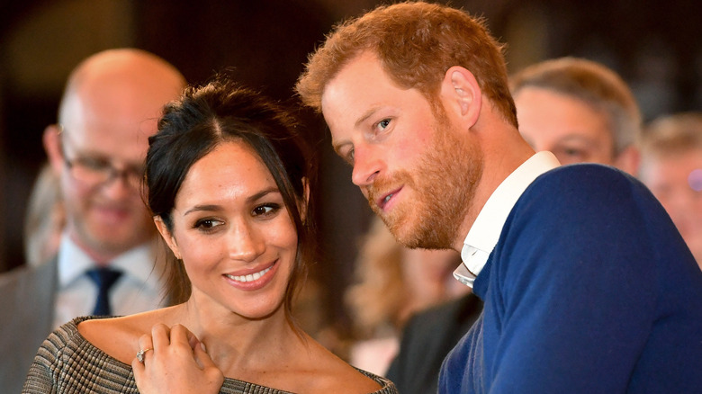 Prince Harry and Meghan Markle whispering