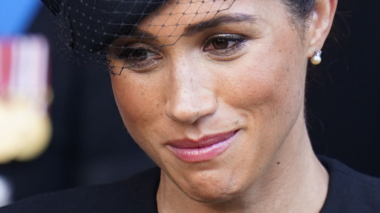 Meghan Markle in funeral hat, eyes looking down