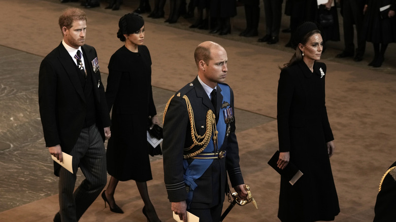 Prince Harry and Meghan Markle hold hands at the queen's funeral event
