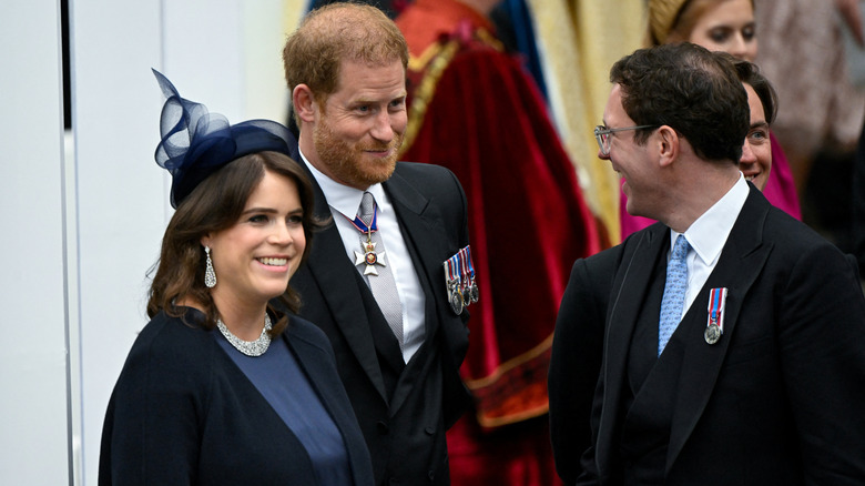 A smiling Prince Harry and Princess Eugenie standing next to each other at King Charles III's coronation