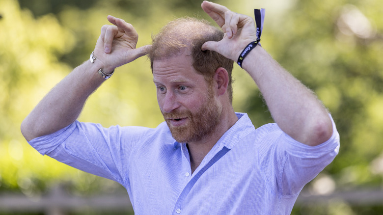 Prince Harry holding his thumbs to his head