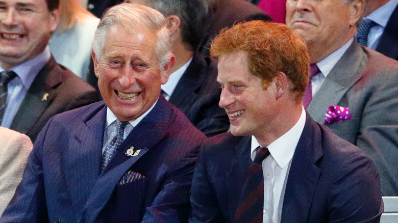 King Charles III and Prince Harry sitting together and smiling