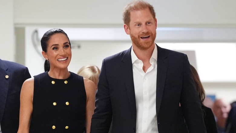 A smiling Meghan Markle and Prince Harry walking next to each other