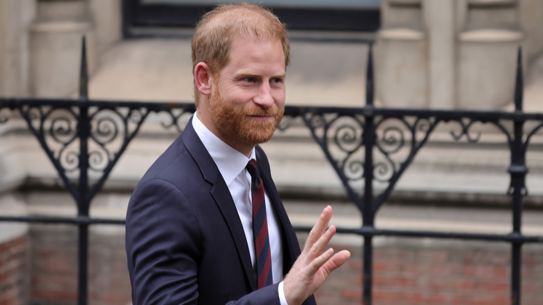 Prince Harry waving at the crowd during his January return to the UK for his lawsuit against the Daily Mail
