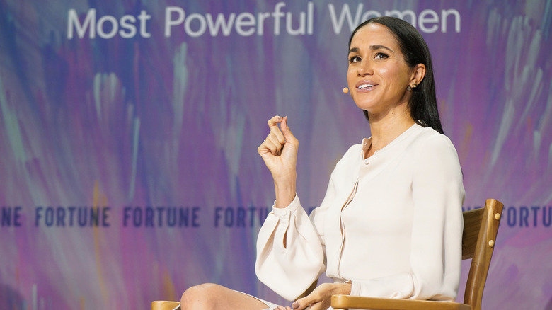 Meghan Markle speaking at a 'Most Powerful Women' event by Forbes in a white dress