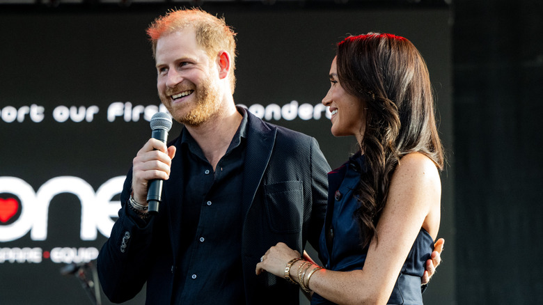 Prince Harry and Meghan Markle smiling onstage