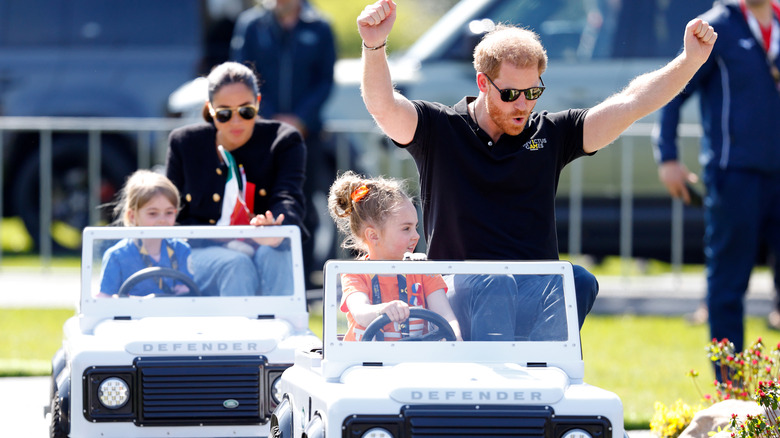 Meghan, Duchess of Sussex and Prince Harry, Duke of Sussex accompany young children driving mini Land Rover Defenders at the Land Rover Driving Challenge, on day 1 of the Invictus Games 2020 at Zuiderpark on April 16, 2022 in The Hague, Netherlands.