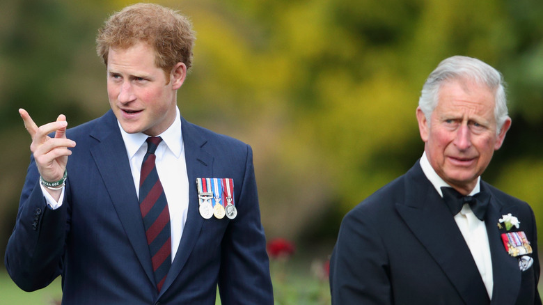 Prince Harry points something out to King Charles