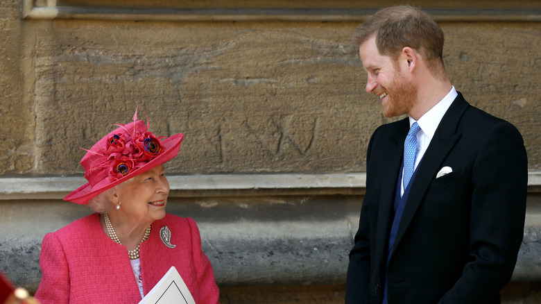 Queen Elizabeth and Prince Harry smiling at each other