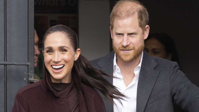 A smiling Meghan Markle and Prince Harry walking next to each other