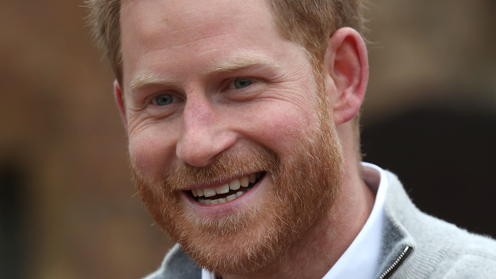 Prince Harry laughs outside 