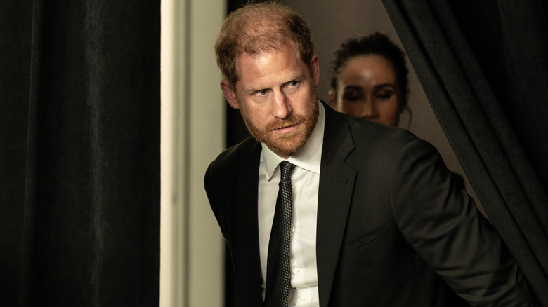 Prince Harry peeking from behind a curtain