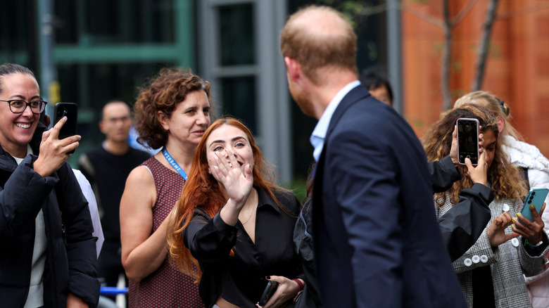 Prince Harry photographed from behind as he greets fans