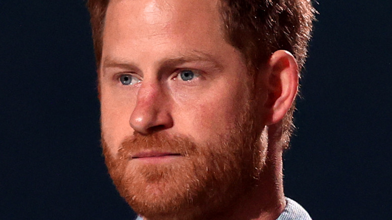 Prince Harry wearing a blue shirt onstage