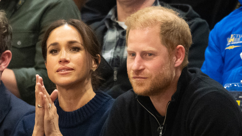 Prince Harry and Meghan Markle sitting next to each other at an event