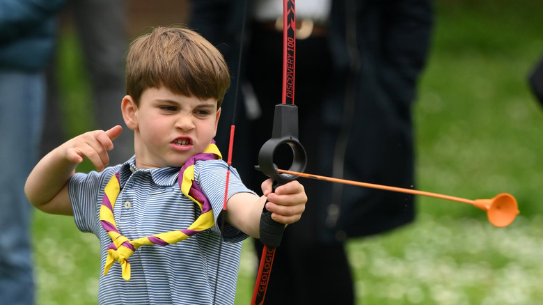 Prince Louis shooting an arrow.
