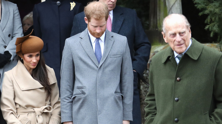 Meghan Markle with Prince Harry (who is looking down) and Prince Philip