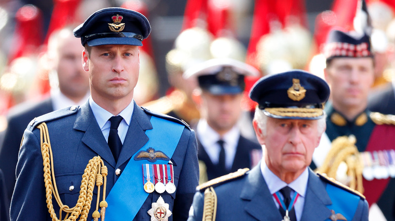 Prince William walking behind King Charles