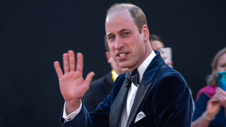 Prince William smiling as he waves at onlookers