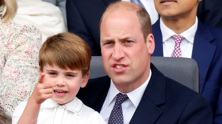 Prince Louis of Cambridge sits on his father Prince William, Duke of Cambridge's lap as they attend the Platinum Pageant on The Mall on June 5, 2022 in London, England (2022)