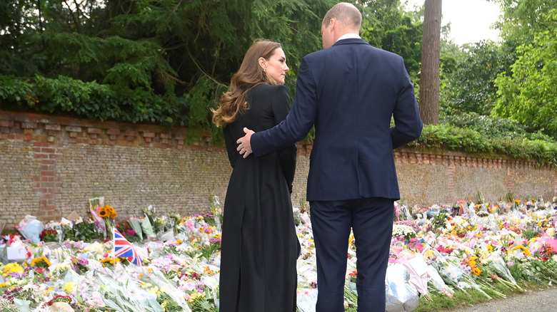 The Prince and Princess of Wales looking at floral tributes to the queen