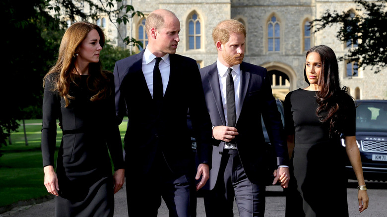 Kate Middleton, Prince William, Prince Harry, and Meghan Markle walking outside of Windsor Castle