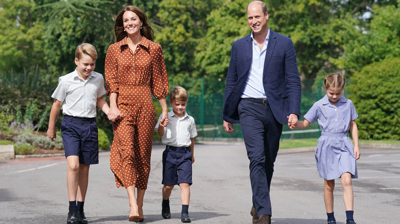 Princess Catherine and Prince William walking hand-in-hand with Prince George, Prince Louis, and Princess Charlotte