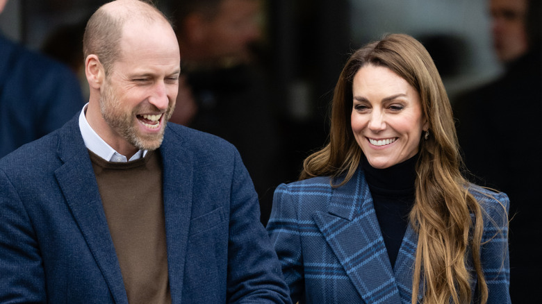 Prince William and Princess Catherine sharing a laugh in complementary navy blue outfits