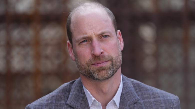 Prince William tilting his head in a check suit