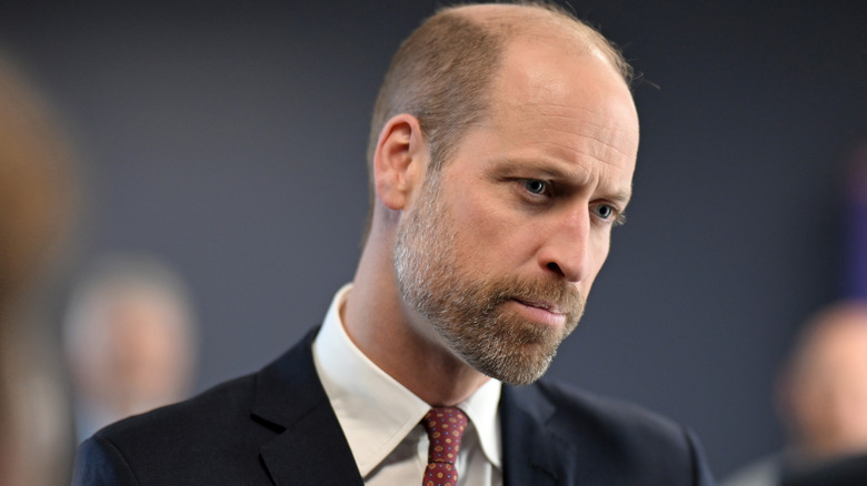 Prince William looking serious in a black suit