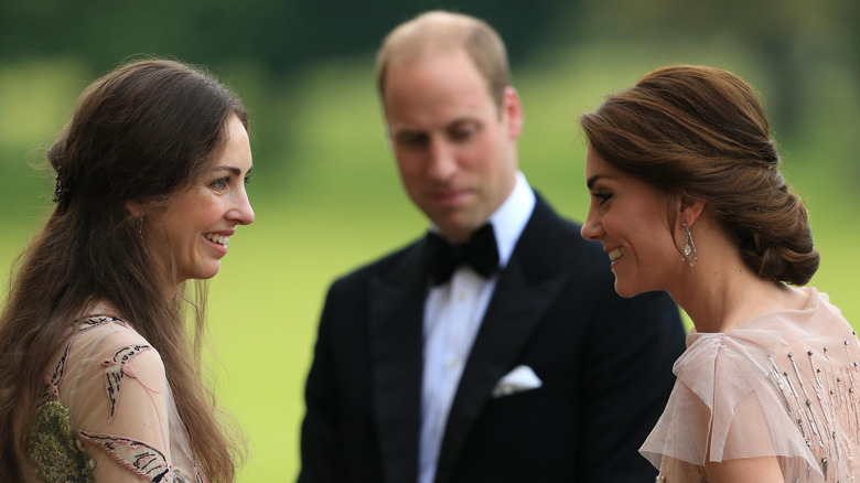 Princess Catherine and Rose Hanbury talking while Prince William stands between them