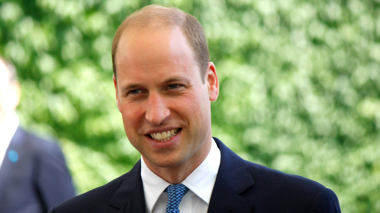 Prince William smiling with greenery