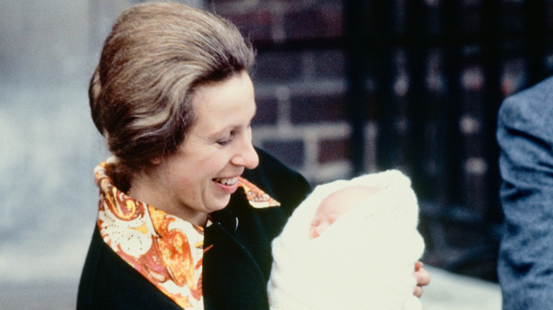 Princess Anne holds a baby Zara Tindall