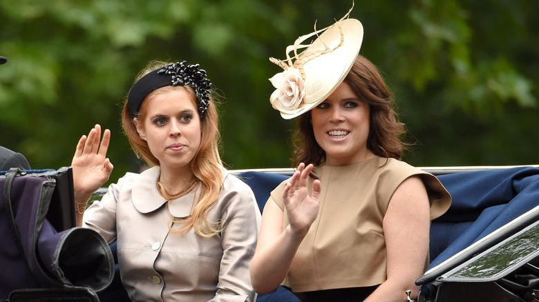 Princess Beatrice and Princess Eugenie wave from a carriage at the 2015 Trooping the Colour
