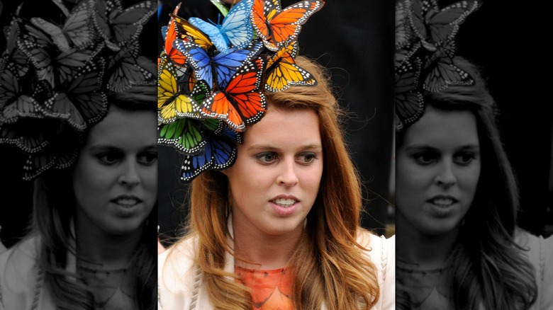 Princess Beatrice wearing a hat made of multicolored fabric butterflies.