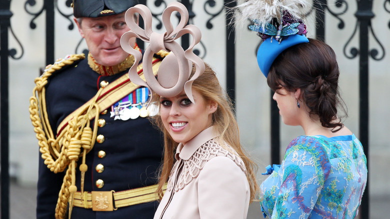 Princess Beatrice's smiling while wearing her pretzel hat at Prince William's wedding.