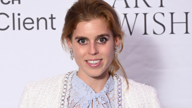Princess Beatrice smiling on the red carpet for the Art of Wishes raffle in 2023.