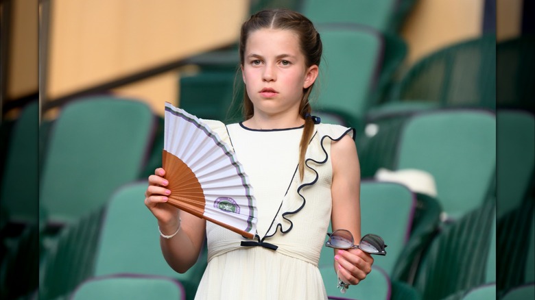 Princess Charlotte waving a fan at Wimbledon 2025