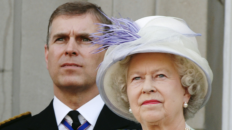 Prince Andrew standing behind Queen Elizabeth 