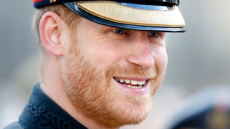 Prince Harry smiling in a hat