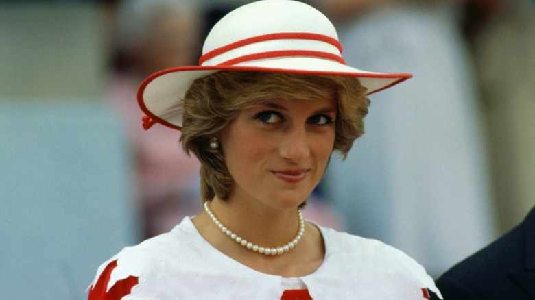Princess Diana looking mischievous in a white hat