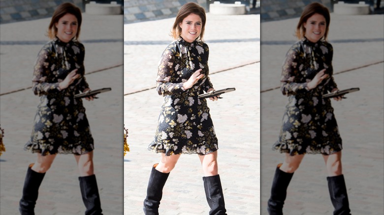 Princess Eugenie at an event in a short black dress and black boots waving at a crowd