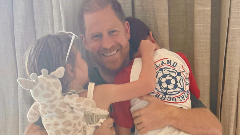 Prince Harry hugging his two kids