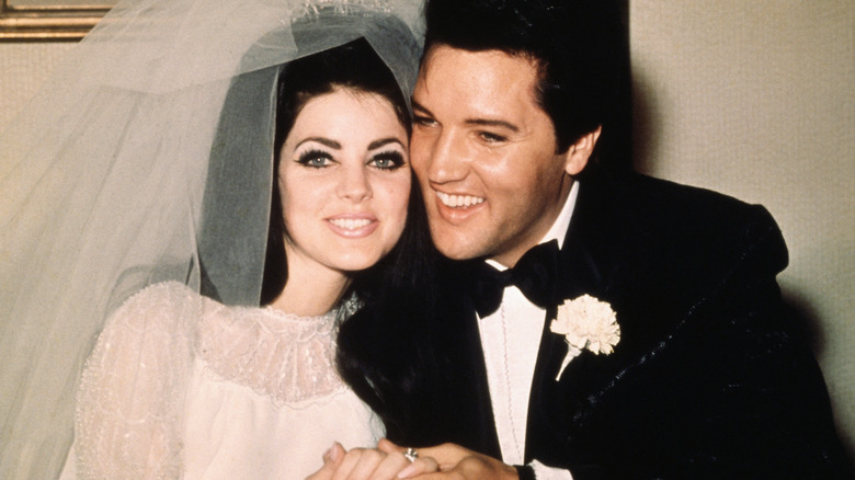 Elvis and Priscilla Presley smiling in their wedding day
