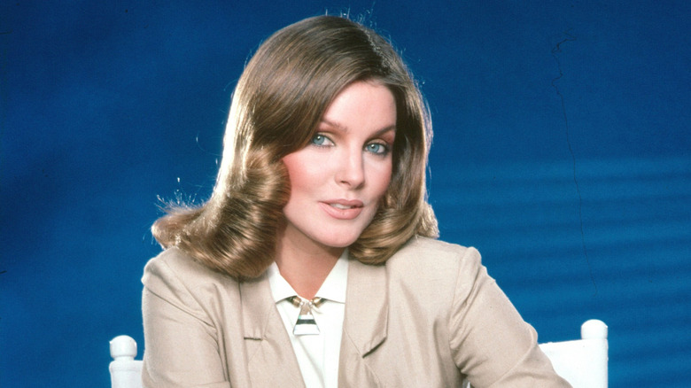 Priscilla Presley in a beige blazer against blue background