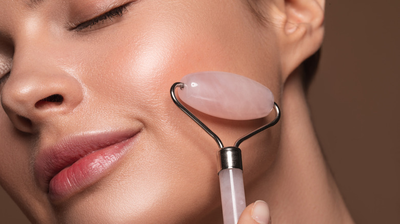 Woman using rose quartz roller